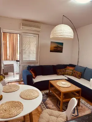 a living room with a blue couch and a table at Levant in Sutomore