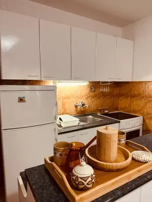 a kitchen with white appliances and a wooden cutting board at Levant in Sutomore