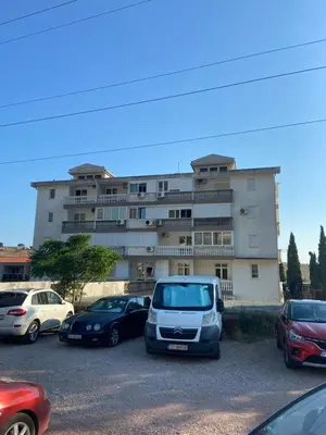 a parking lot with cars parked in front of a building at Levant in Sutomore