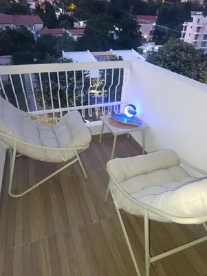 a balcony with white chairs and a view of a city at Sofi in Sutomore