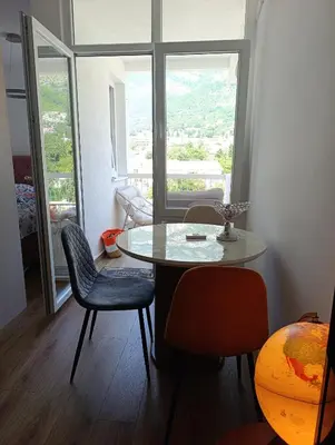 a table and chairs in a room with a window at Sofi in Sutomore