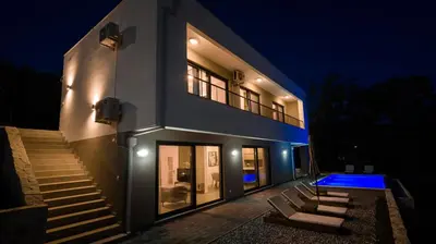 a house with stairs and a swimming pool at night at Villa Amara -Luxury Villa with Private Pool & Hot Tub in Bar