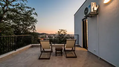 a patio with two chairs and a table on a balcony at Villa Amara -Luxury Villa with Private Pool & Hot Tub in Bar