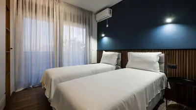 two beds in a room with a blue wall at Villa Amara -Luxury Villa with Private Pool & Hot Tub in Bar