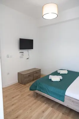 a bedroom with a bed and a flat screen tv at Odore di mare in Ulcinj