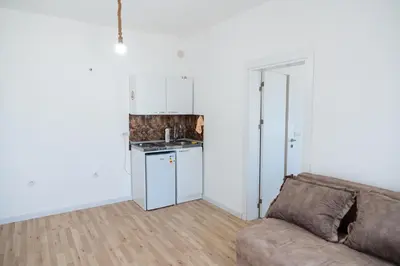 a living room with a couch and a kitchen at Odore di mare in Ulcinj