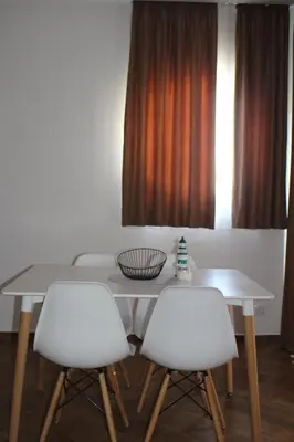 a dining room table with two white chairs and a window at AMD - stan 211 in Bar
