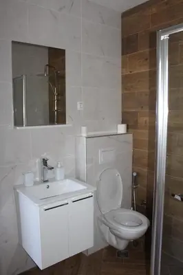 a white bathroom with a toilet and a sink at AMD - stan 211 in Bar