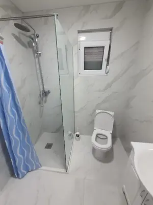 a bathroom with a shower and a toilet at Apartmani Ajla in Donji Štoj