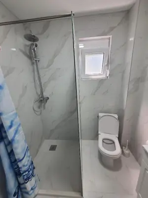a bathroom with a shower and a toilet at Apartmani Ajla in Donji Štoj