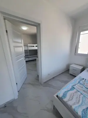 a bedroom with a bed and an open door at Apartmani Ajla in Donji Štoj