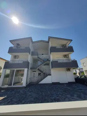 a large white building with a staircase on it at Apartmani Ajla in Donji Štoj