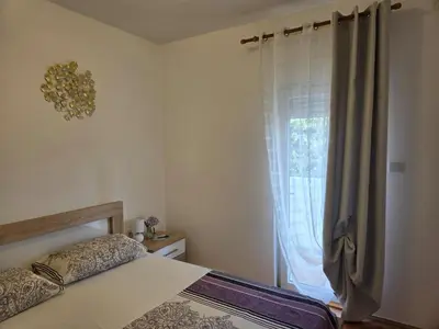 a bedroom with a bed and a large window at Тишина и покой в Будве in Kravlja
