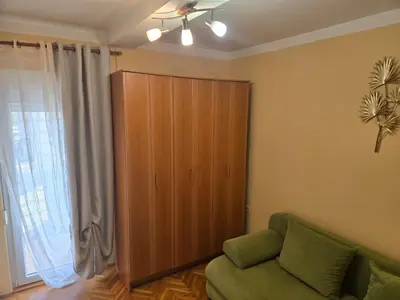 a living room with a green couch and a large window at Тишина и покой в Будве in Kravlja