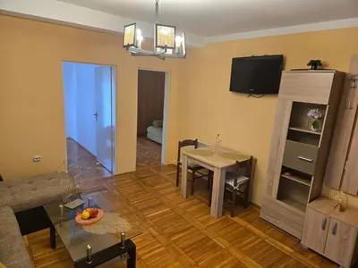 a living room with a table and a dining room at Тишина и покой в Будве in Kravlja