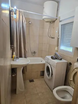 a bathroom with a washing machine and a sink at Тишина и покой в Будве in Kravlja