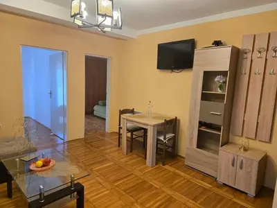 a living room with a table and a dining room at Тишина и покой в Будве in Kravlja