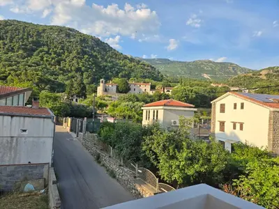a street in a small town with a mountain at Тишина и покой в Будве in Kravlja