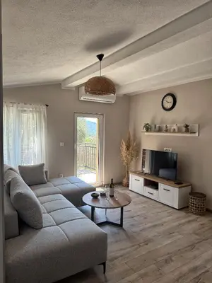 a living room with a couch and a table at Apartmani Krsto in Kravlja