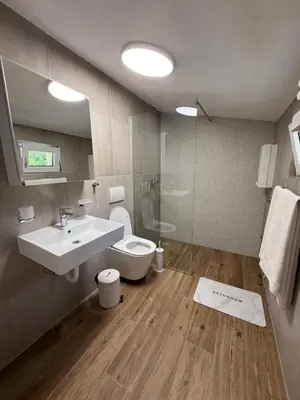 a bathroom with a sink and a toilet and a mirror at Apartmani Krsto in Kravlja