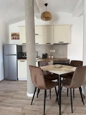 a kitchen with a table and chairs in a room at Apartmani Krsto in Kravlja