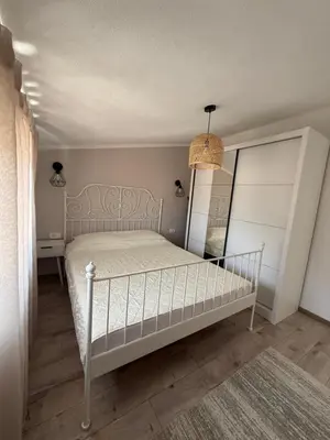 a bedroom with a white bed and a mirror at Apartmani Krsto in Kravlja