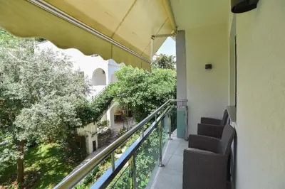 a balcony of a building with chairs and trees at Omega 4 Apartment in Budva