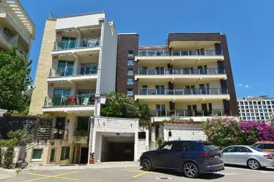 a car parked in a parking lot in front of a building at Omega 4 Apartment in Budva