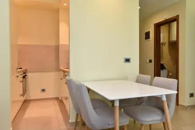 a dining room with a white table and chairs at Omega 4 Apartment in Budva