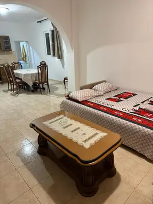 a room with two beds and a table with a tableablishthritisthritisthritisthritis at Stuart Žukotrlica in Bar
