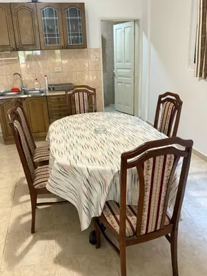 a kitchen with a table with four chairs and a sink at Stuart Žukotrlica in Bar