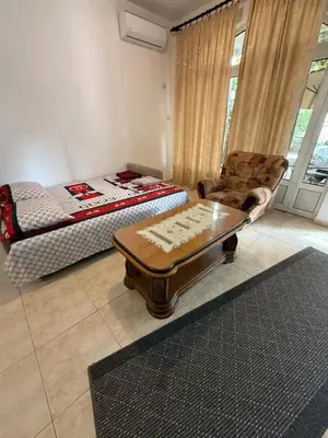 a living room with a bed and a table and a chair at Stuart Žukotrlica in Bar