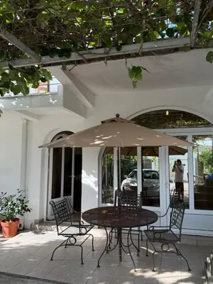 a table and chairs under an umbrella on a patio at Stuart Žukotrlica in Bar