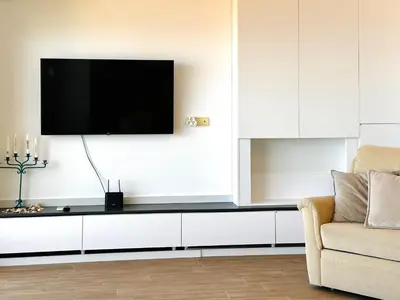 a living room with a tv on a wall at GlamSea in Bar