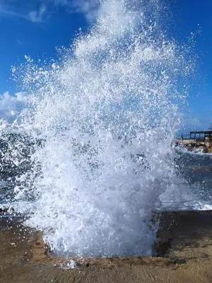 a large splash of water on the beach at GlamSea in Bar