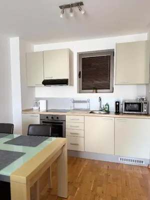 a kitchen with white cabinets and a table and a sink at Infinity Apartment Blue Horizont Przno in Kravlja