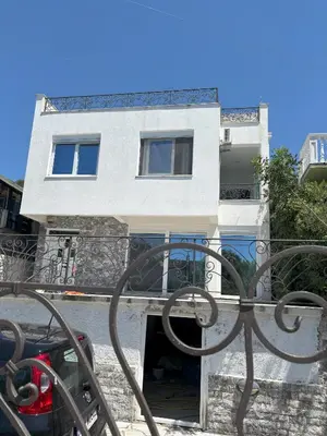 a white building with a gate in front of it at Villa Diel 300m vom Strand in Utjeha