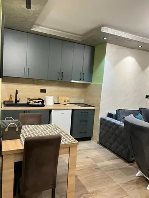 a kitchen and living room with a table and a couch at Kasia in Kravlja