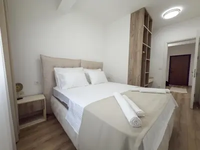 a bedroom with a white bed with white sheets and pillows at Amarea Apartments in Ulcinj