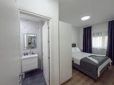 a bedroom with a bed and a sink and a mirror at Amarea Apartments in Ulcinj