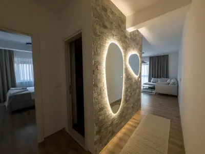 a room with a stone wall with a round mirror at Amarea Apartments in Ulcinj