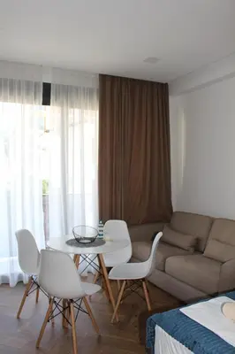 a living room with a couch and a table and chairs at AMD - studio104 in Dobra Voda