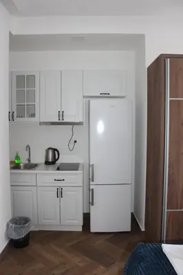 a kitchen with white cabinets and a white refrigerator at AMD - studio104 in Dobra Voda