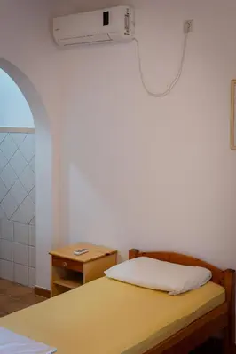 a bedroom with a bed and a desk with a fan at Apartments Noki in Ulcinj