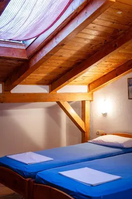a bed in a room with a wooden ceiling at Apartments Noki in Ulcinj