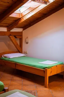 a bed in a room with a wooden ceiling at Apartments Noki in Ulcinj