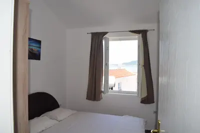 a bedroom with a bed and a window at Apartment Vidakovic in Budva