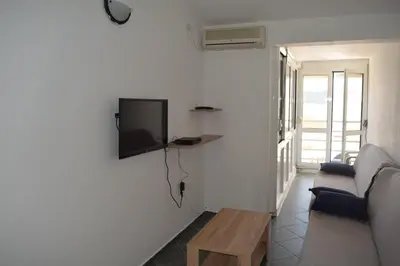 a living room with a couch and a tv on the wall at Apartment Vidakovic in Budva