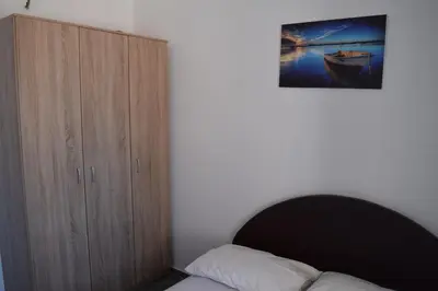 a bedroom with a bed and a wooden cabinet at Apartment Vidakovic in Budva