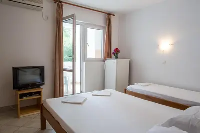 a small room with two beds and a television at Guest House Violet in Becici